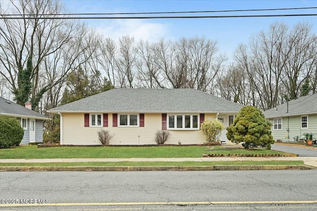 view of front of property featuring a front yard and roof with shingles