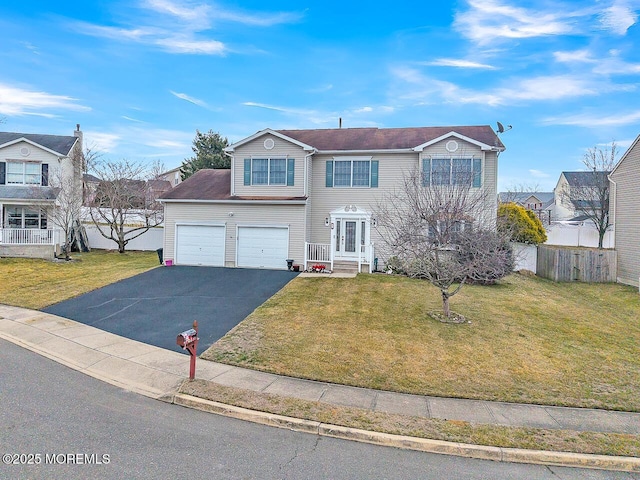 traditional-style home with fence, a front lawn, and aphalt driveway