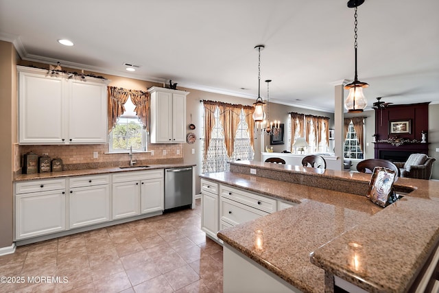 kitchen featuring a sink, white cabinetry, dishwasher, tasteful backsplash, and pendant lighting