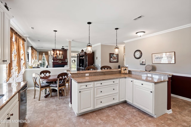 kitchen featuring hanging light fixtures, ornamental molding, and visible vents