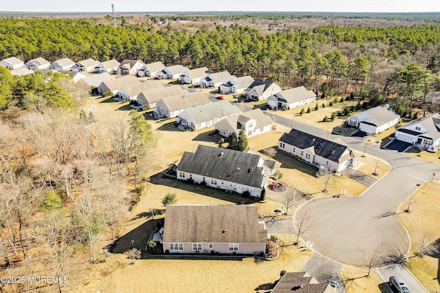 drone / aerial view featuring a residential view and a wooded view