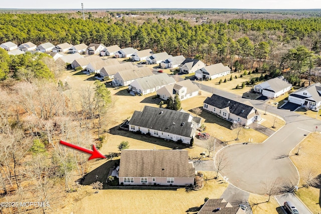 drone / aerial view featuring a residential view and a wooded view