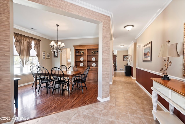 dining room with a notable chandelier, light tile patterned floors, visible vents, ornamental molding, and baseboards