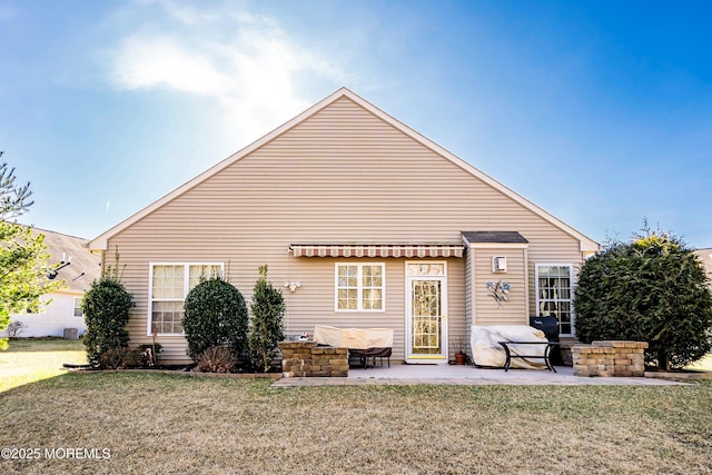 rear view of house featuring a patio and a yard