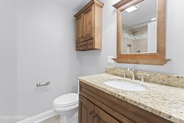 bathroom featuring walk in shower, vanity, toilet, and baseboards