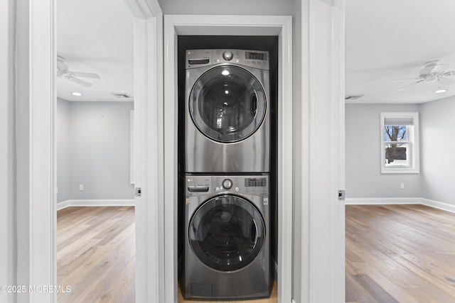 washroom with ceiling fan, stacked washer / dryer, wood finished floors, and baseboards