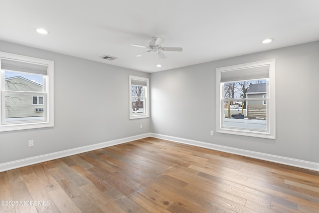 unfurnished room with hardwood / wood-style floors, recessed lighting, and baseboards