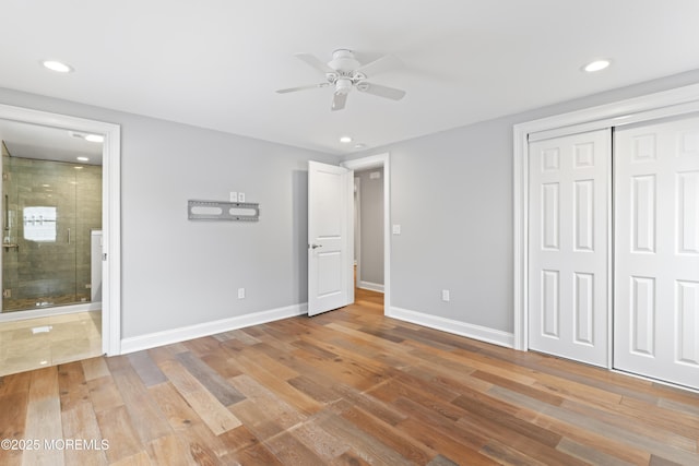 unfurnished bedroom featuring a closet, baseboards, and wood finished floors