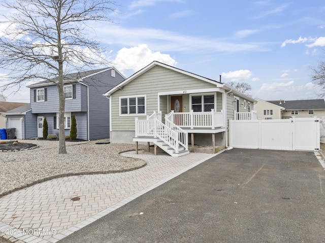 view of front of house featuring covered porch, a gate, and fence