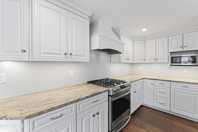 kitchen with appliances with stainless steel finishes, custom exhaust hood, and white cabinets