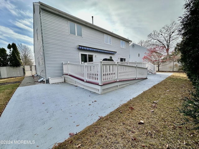 back of house featuring fence and a deck