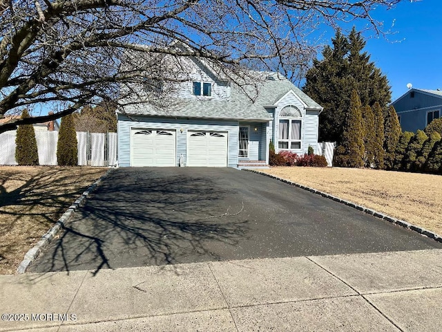 view of front of house with fence and aphalt driveway