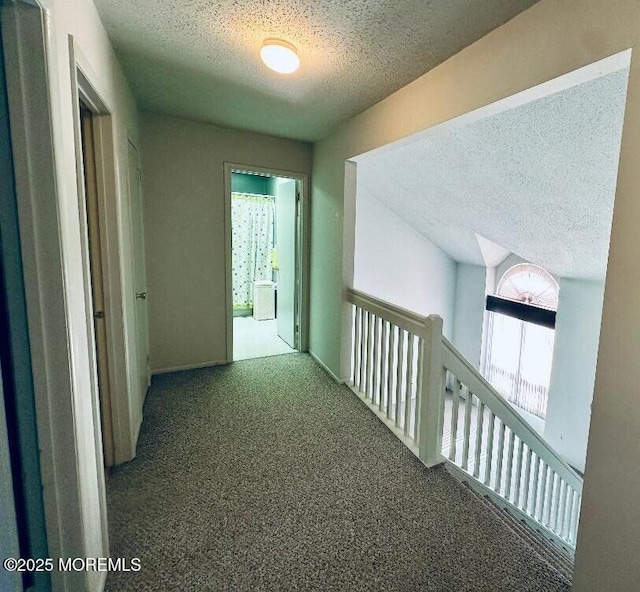 hallway featuring carpet flooring and a textured ceiling