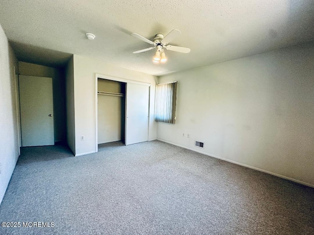 unfurnished bedroom featuring baseboards, visible vents, a textured ceiling, carpet flooring, and a closet