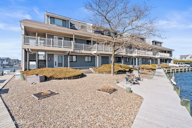 view of front of house with a dock and a water view