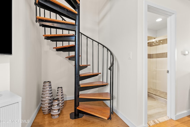 stairway with recessed lighting, baseboards, and wood finished floors