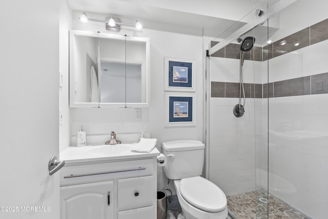 full bath with a stall shower, vanity, and toilet