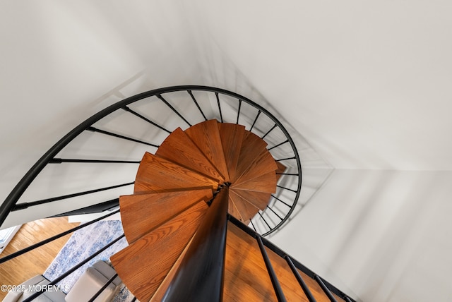 stairway featuring lofted ceiling and wood finished floors