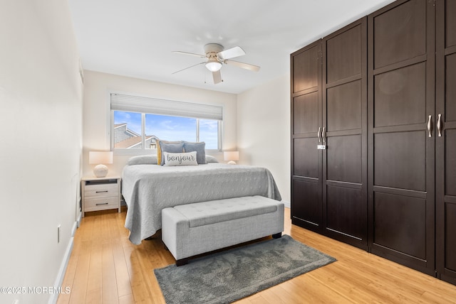 bedroom with light wood-type flooring, ceiling fan, and baseboards