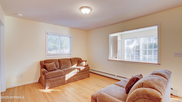 living area with wood finished floors, a baseboard heating unit, baseboards, and a baseboard radiator