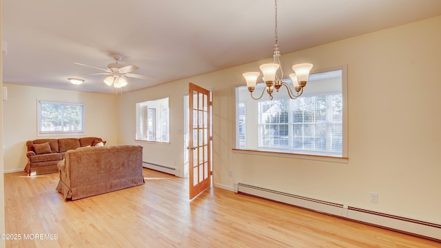 living room with ceiling fan with notable chandelier, wood finished floors, baseboards, and baseboard heating