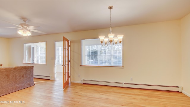 dining space featuring ceiling fan with notable chandelier, light wood-style floors, baseboards, and baseboard heating