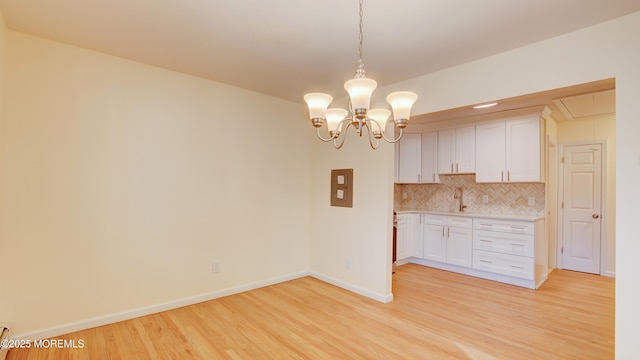 kitchen with decorative backsplash, light wood-style flooring, white cabinetry, and light countertops