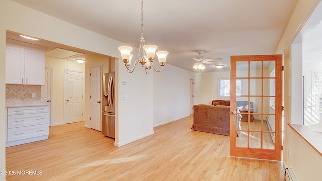 interior space featuring tasteful backsplash, a baseboard heating unit, stainless steel fridge with ice dispenser, light wood-style floors, and white cabinets