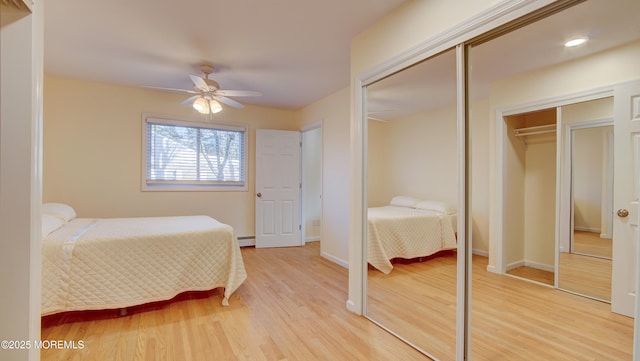 bedroom featuring light wood finished floors, ceiling fan, a baseboard heating unit, and baseboards