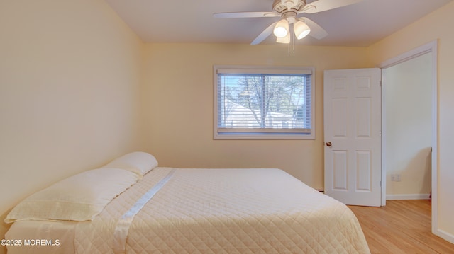 bedroom featuring light wood-type flooring, baseboards, and ceiling fan