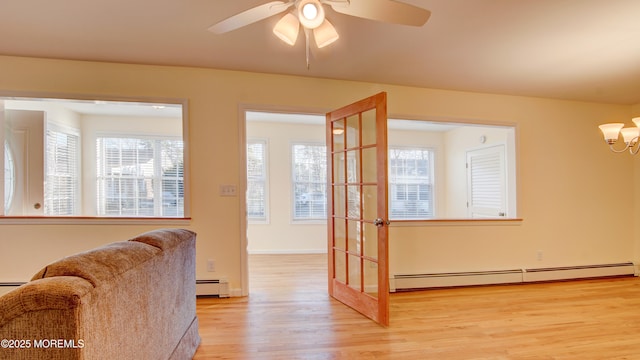 interior space featuring a baseboard heating unit, light wood-style flooring, and a healthy amount of sunlight