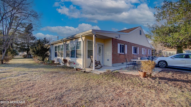 view of front of house featuring a patio and a front lawn