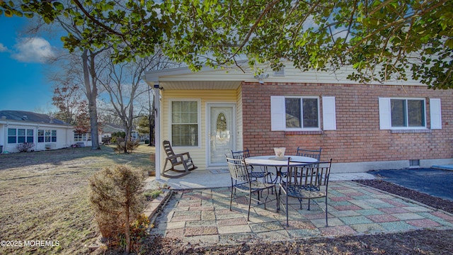 exterior space featuring brick siding and a patio area