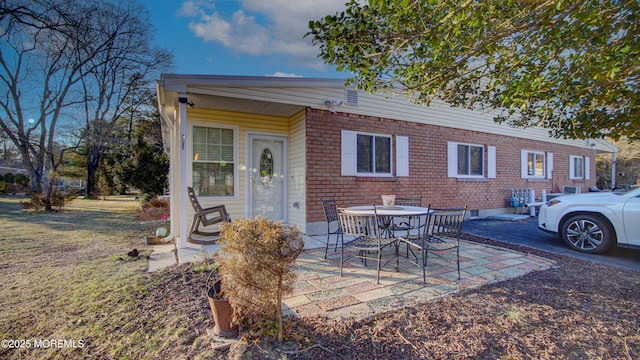 view of front of home with a patio area and brick siding