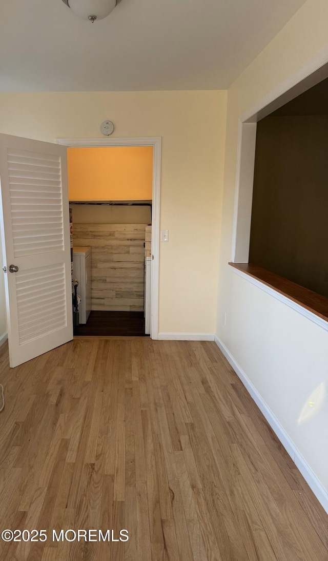 unfurnished room with baseboards and wood finished floors