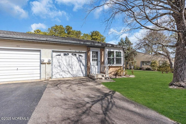 view of front of home featuring a front lawn and aphalt driveway