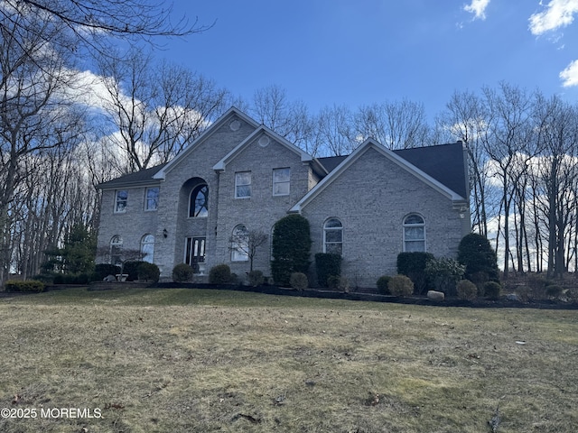 view of front of home with a front yard and brick siding