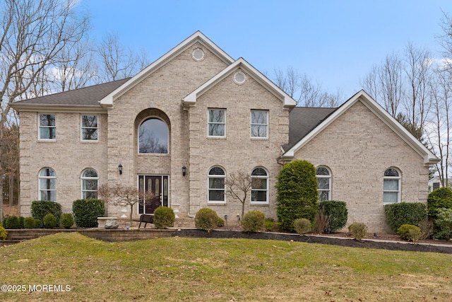 view of front of house featuring brick siding and a front lawn