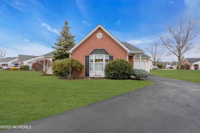 view of front of house with brick siding, roof with shingles, a garage, driveway, and a front lawn