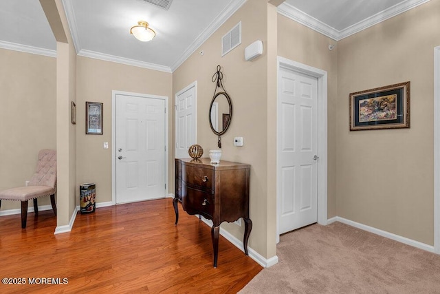 entryway featuring visible vents, crown molding, and baseboards