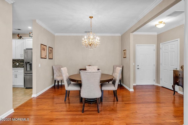 dining area with baseboards, light wood-type flooring, visible vents, and crown molding