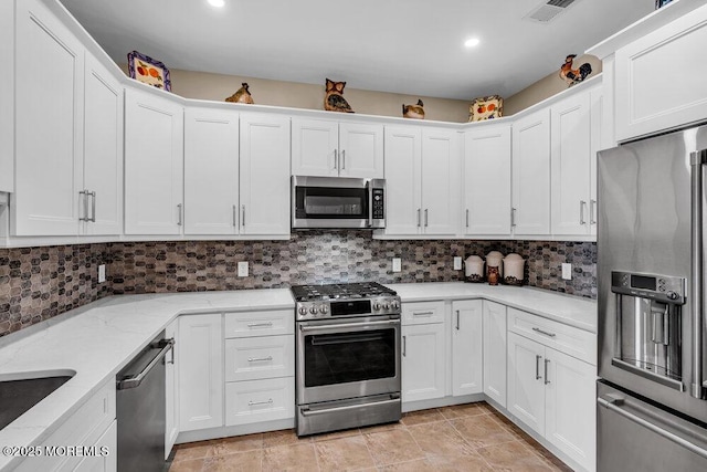 kitchen with white cabinets, visible vents, stainless steel appliances, and backsplash