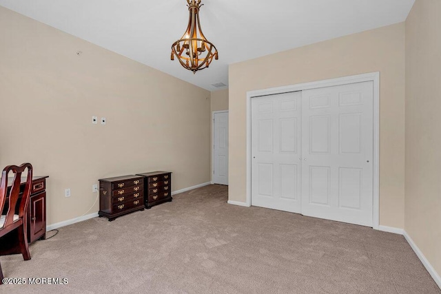 bedroom with a notable chandelier, carpet floors, a closet, and baseboards