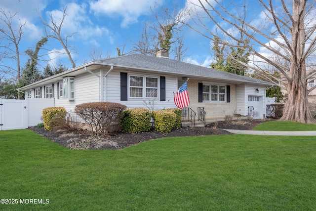 ranch-style home featuring brick siding, a chimney, an attached garage, and a front yard