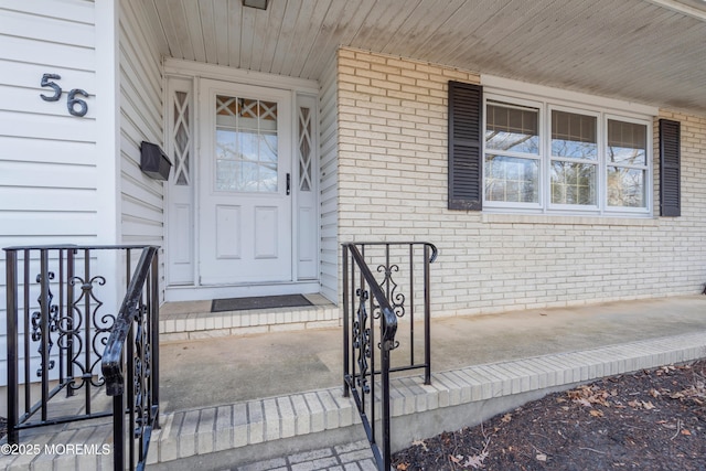 view of exterior entry featuring brick siding