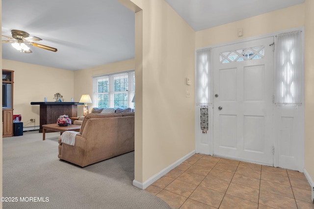 entryway with light tile patterned floors, baseboards, a ceiling fan, light colored carpet, and baseboard heating