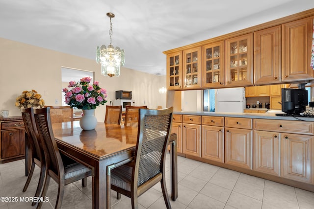 dining space with light tile patterned floors and an inviting chandelier