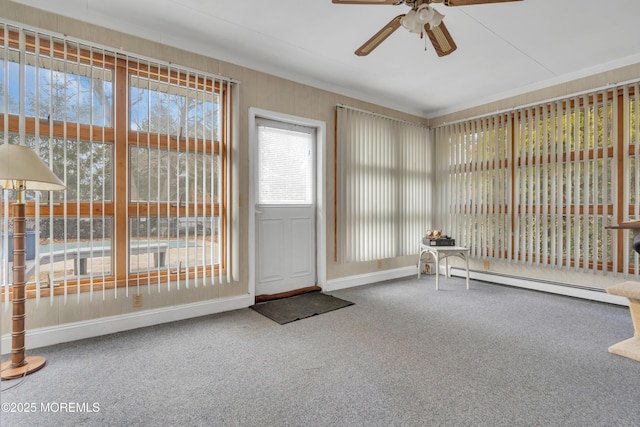 interior space with carpet floors, baseboard heating, a ceiling fan, and crown molding