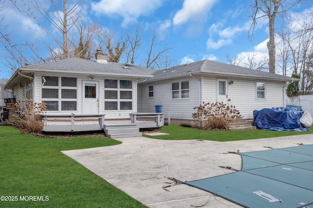 rear view of house featuring a fenced in pool, a chimney, a sunroom, a patio area, and a deck