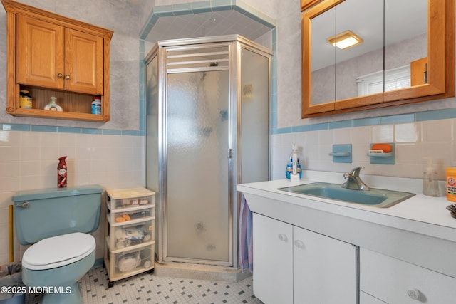 full bath with toilet, a stall shower, tile walls, and vanity